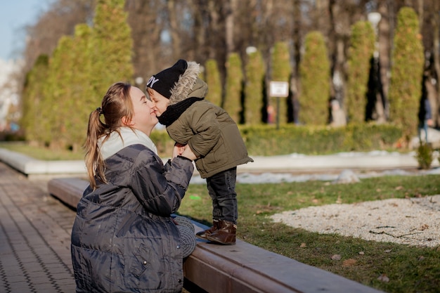 Niño feliz besando a la madre al aire libre