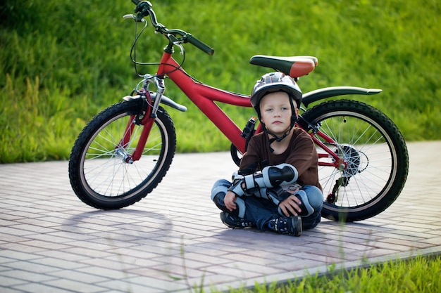 Niño feliz en bicicleta en el parque por la tarde