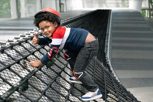 Niño feliz con cabello afro en el patio de recreo en el parque