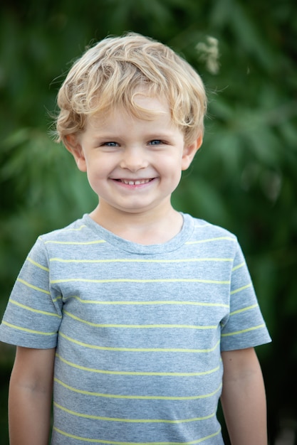 Niño feliz con camiseta azul en el jardín