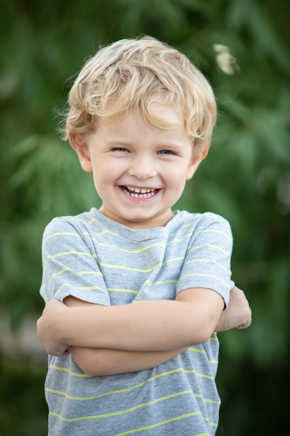 Niño feliz con camiseta azul en el jardín