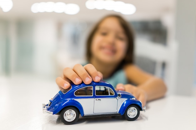 Niño feliz en casa con juego de juguete de coche oldtimer