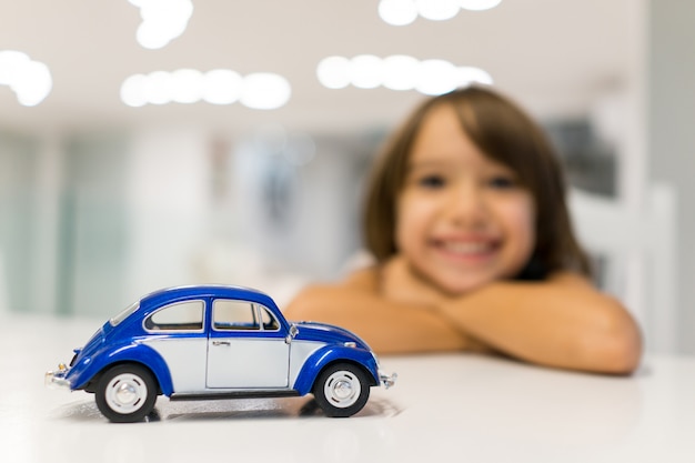Foto niño feliz en casa con juego de juguete de coche oldtimer