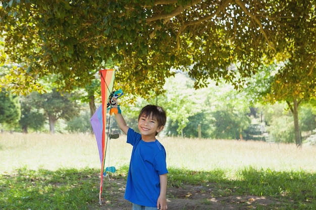 Niño feliz celebración de cometa en el parque