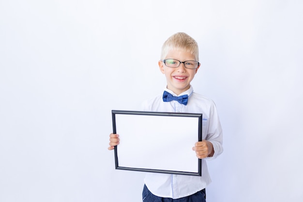 Niño feliz colegial en vasos tiene un cartel de texto