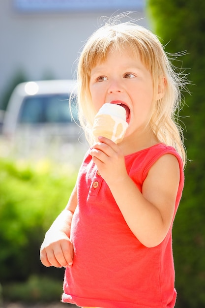 Niño feliz comiendo helado en la naturaleza del parque