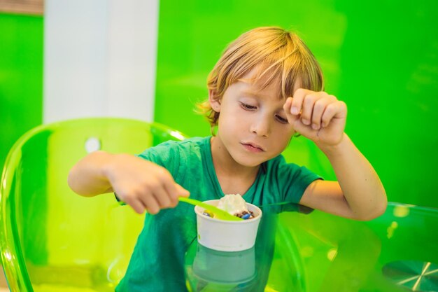 Niño feliz comiendo un sabroso helado o yogur helado