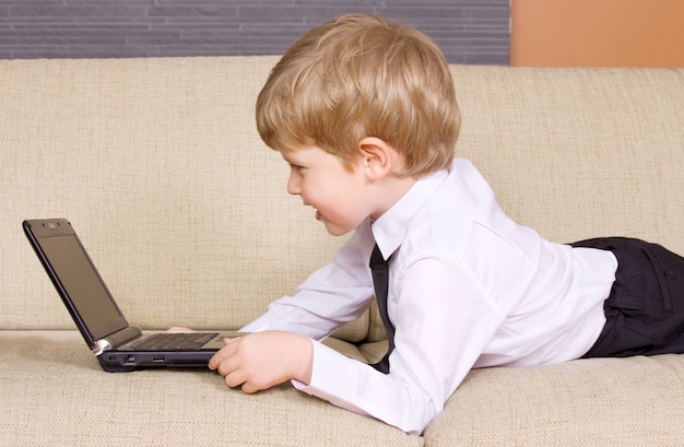 niño feliz con computadora portátil negra