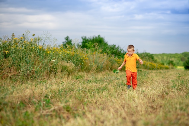 Niño feliz corriendo por el campo en verano