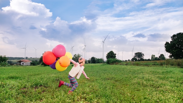 Niño feliz corriendo con globos