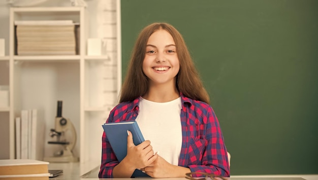Niño feliz con cuaderno regreso a la escuela niña adolescente lista para estudiar niño hacer tarea con libro