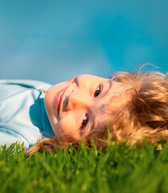 Niño feliz disfrutando en la hierba y soñando con relajarse en la naturaleza vacaciones de verano con la libertad de los niños