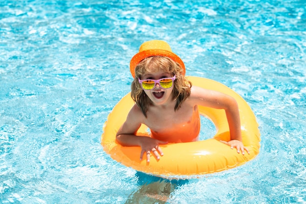 Niño feliz disfrutando de las vacaciones de verano al aire libre en el agua de la piscina