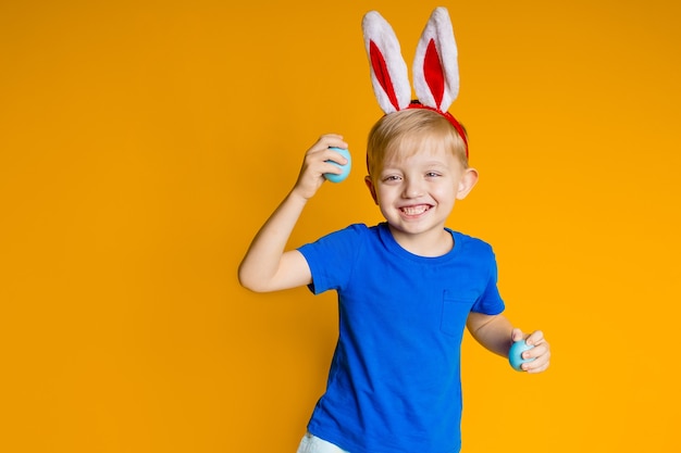 Niño feliz divertido sobre un fondo amarillo, tema de Pascua