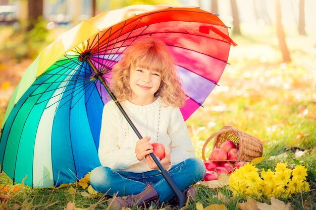 Niño feliz divirtiéndose al aire libre en el parque otoño