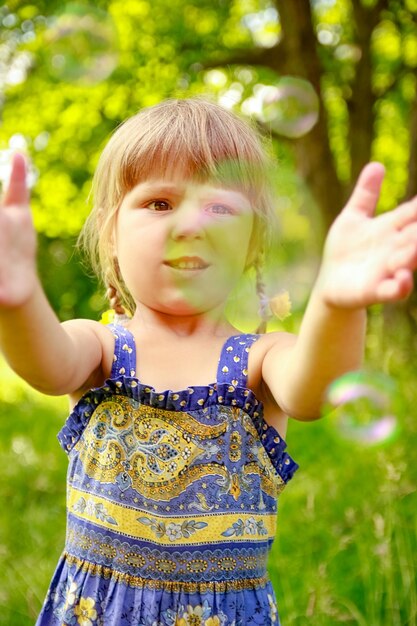 Un niño feliz divirtiéndose jugando en el parque natural.