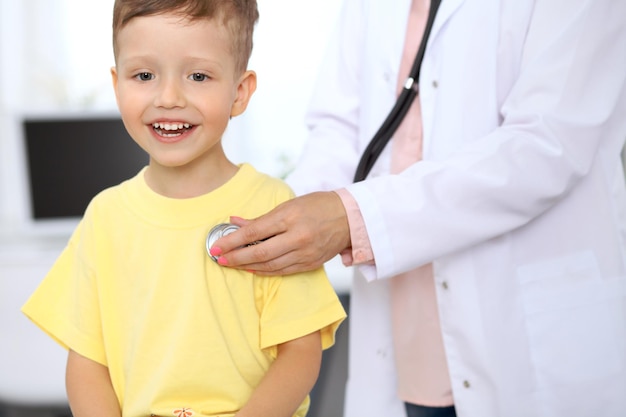 Un niño feliz divirtiéndose mientras lo examina un médico con estetoscopio