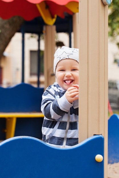 Niño feliz divirtiéndose en el patio de recreo al aire libre