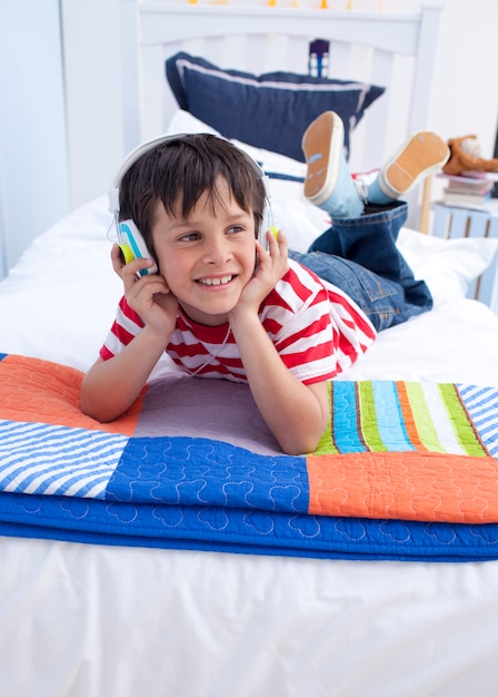 Niño feliz escuchando música con auriculares en