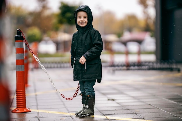 Un niño feliz está jugando con cadenas en el lugar de estacionamiento