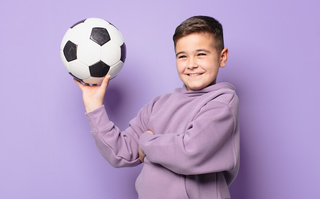 Niño feliz expresión y sosteniendo un balón de fútbol