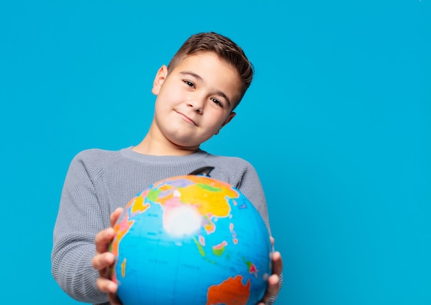 Niño feliz expresión y sosteniendo un modelo de mapa del mundo