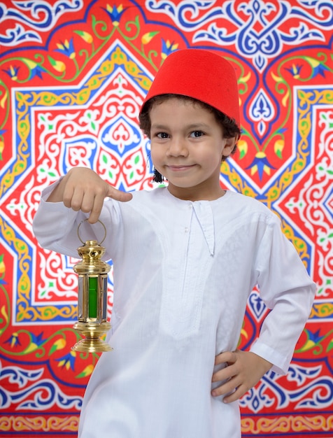 Niño feliz con Fez y linterna celebrando el Ramadán