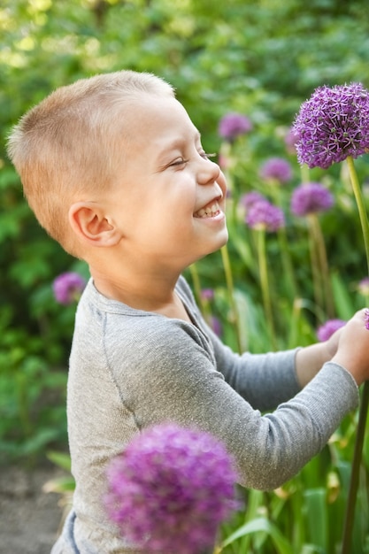 Un niño feliz con una flor en la naturaleza en el viaje de vacaciones del parque