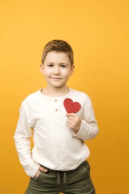 Niño feliz con forma de corazón rojo aislado. Concepto de día de San Valentín.