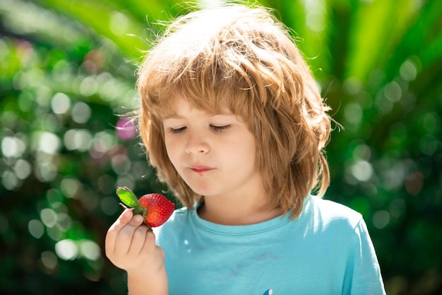 Niño feliz con fresas frescas