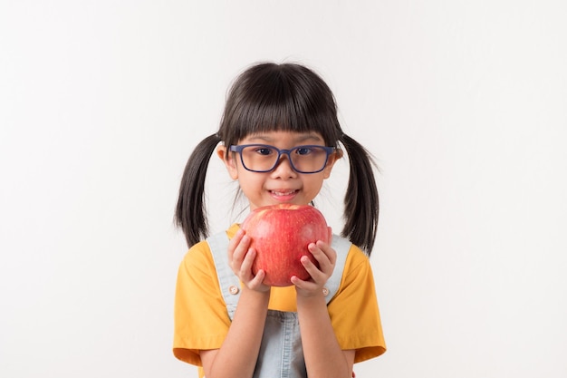 Niño feliz con fruta. Linda chica smilling con manzana roja.