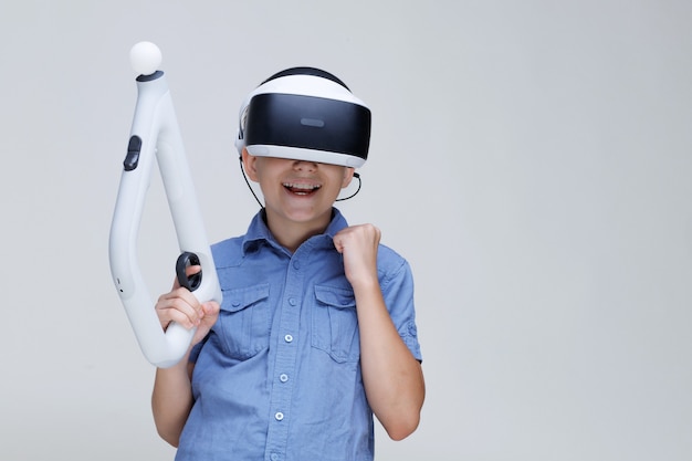 Niño feliz en gafas de realidad virtual sobre fondo gris