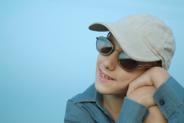 Niño feliz en gafas de sol en el fondo de la naturaleza