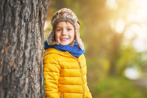 niño feliz jugando afuera en otoño