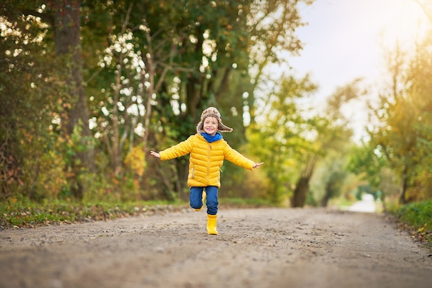 niño feliz jugando afuera en otoño