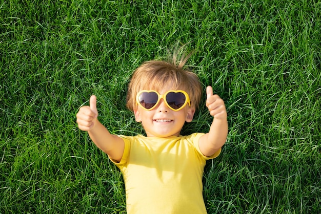 Niño feliz jugando al aire libre en el parque de primavera