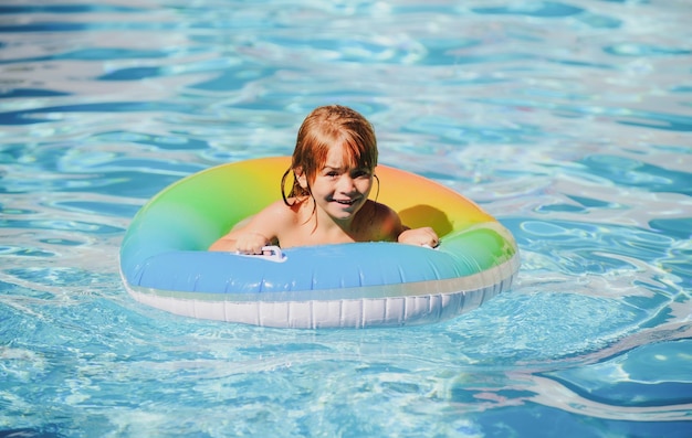 Niño feliz jugando con anillo de flotador de natación en la piscina vacaciones de verano estilo de vida saludable para niños
