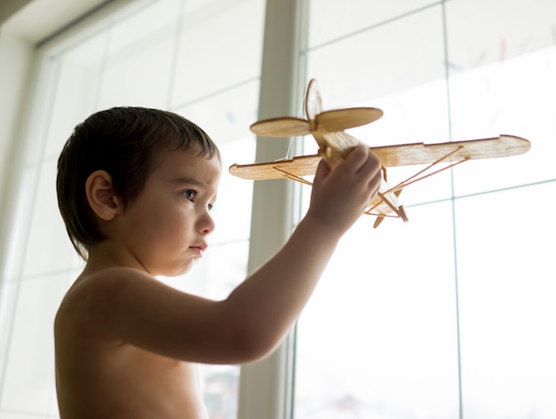 Niño feliz jugando con avión de juguete