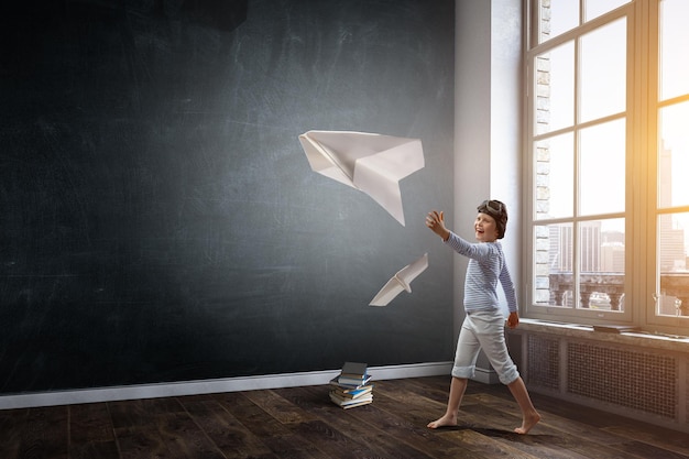 Niño feliz jugando con avión de papel. Técnica mixta