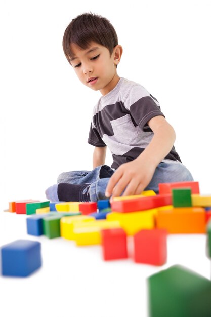 Niño feliz jugando con bloques de construcción