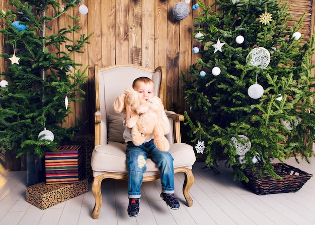 Niño feliz jugando cerca del árbol de Navidad