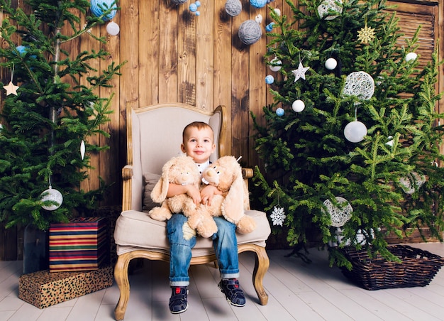 Niño feliz jugando cerca del árbol de Navidad