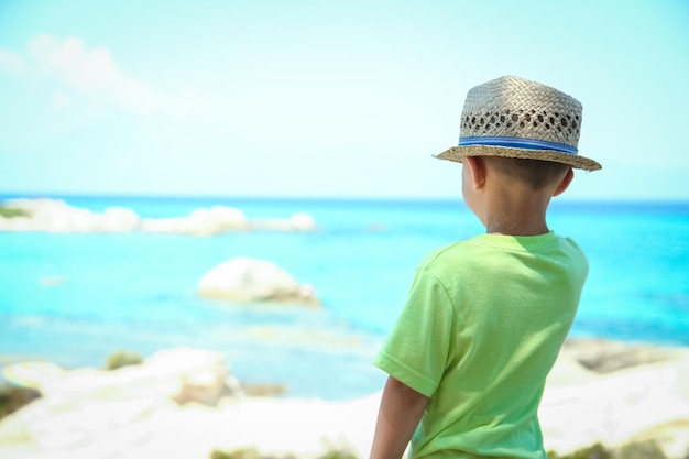 Foto niño feliz jugando junto al mar