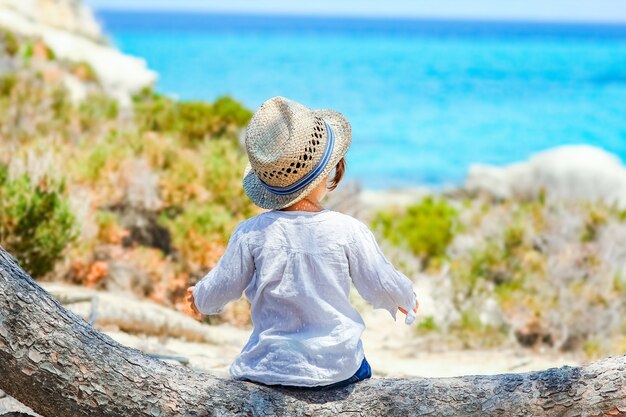 Niño feliz jugando junto al mar