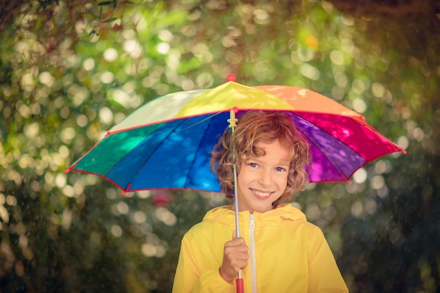 Niño feliz jugando bajo la lluvia