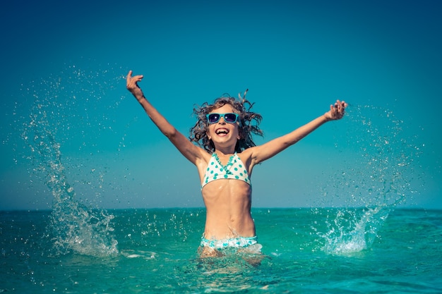 niño feliz jugando en el mar