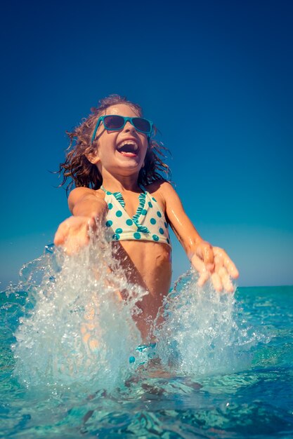 niño feliz jugando en el mar