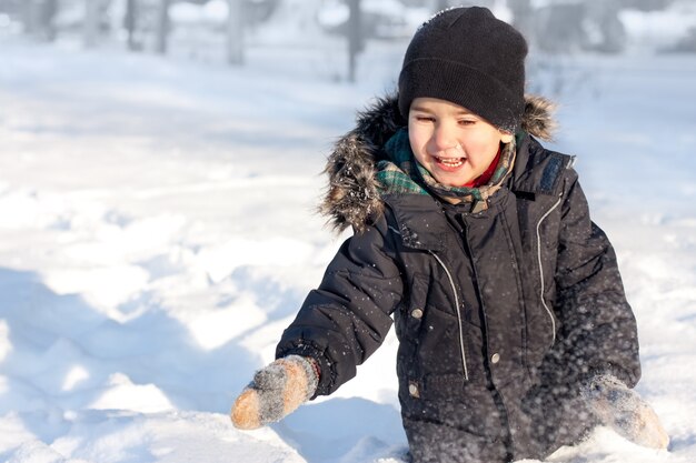 Niño feliz jugando en la nieve