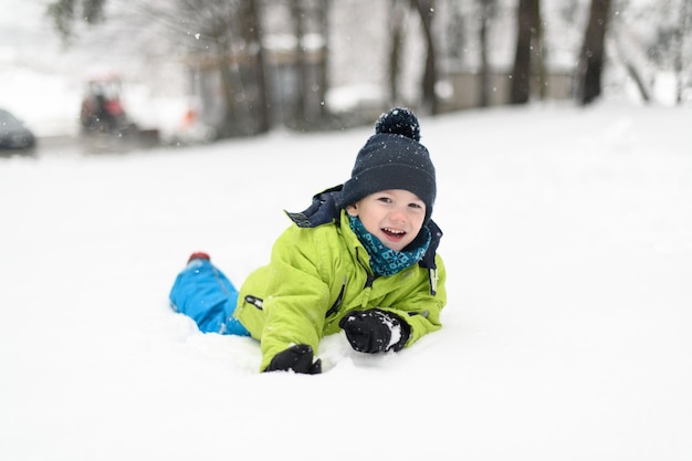 Foto un niño feliz está jugando en la nieve