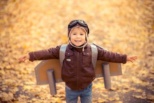 Niño feliz jugando en otoño